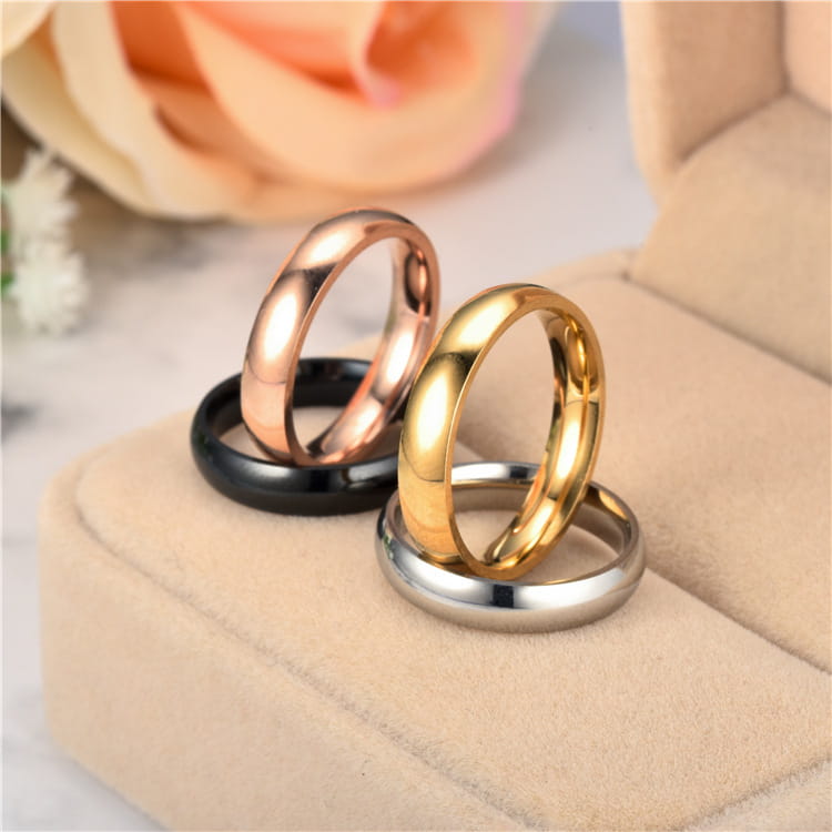 Set of four sleek polished stainless steel wedding bands in rose gold yellow gold black and silver finishes featuring a 6mm width rose gold ring.