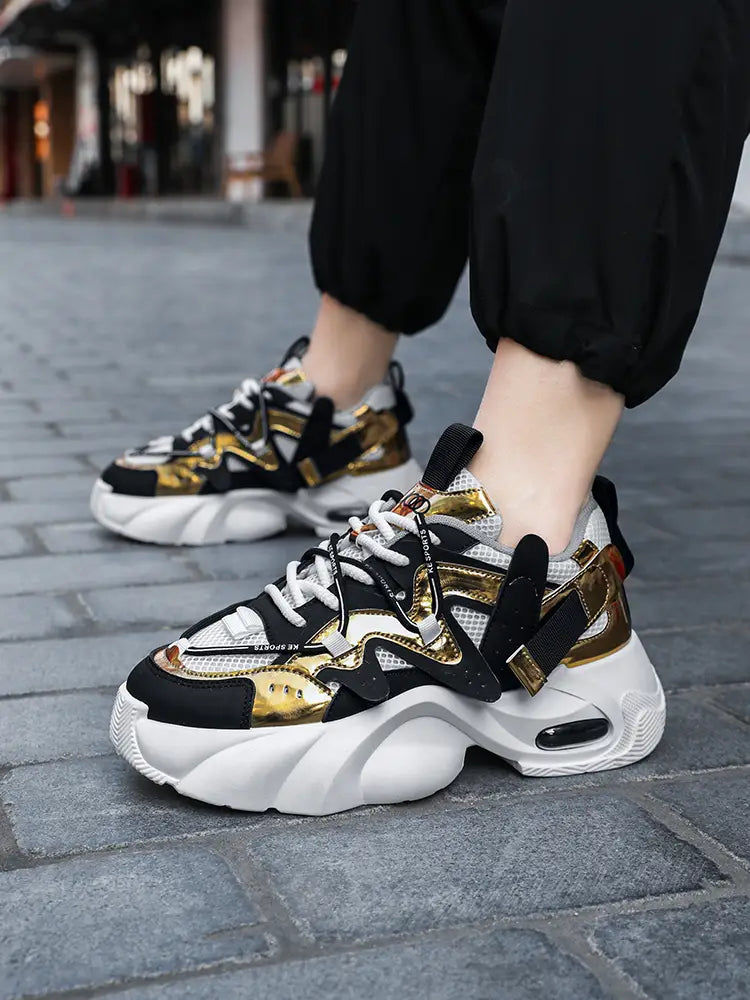Men chunky air cushion casual sneakers in black and gold with white mesh accents and a thick cushioned platform sole.