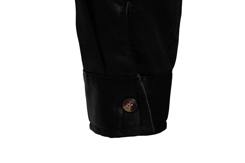 Manschette einer schwarzen Lederjacke mit einem goldfarbenen Knopf, der zusammen mit dem Herrenhemd mit goldfarbenem Besatz aus Satin gezeigt wird