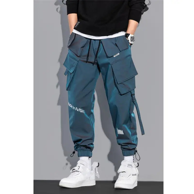 Teal mens tactical cargo pants in durable fabric featuring multiple pockets and drawstring cuffs for streetwear use.