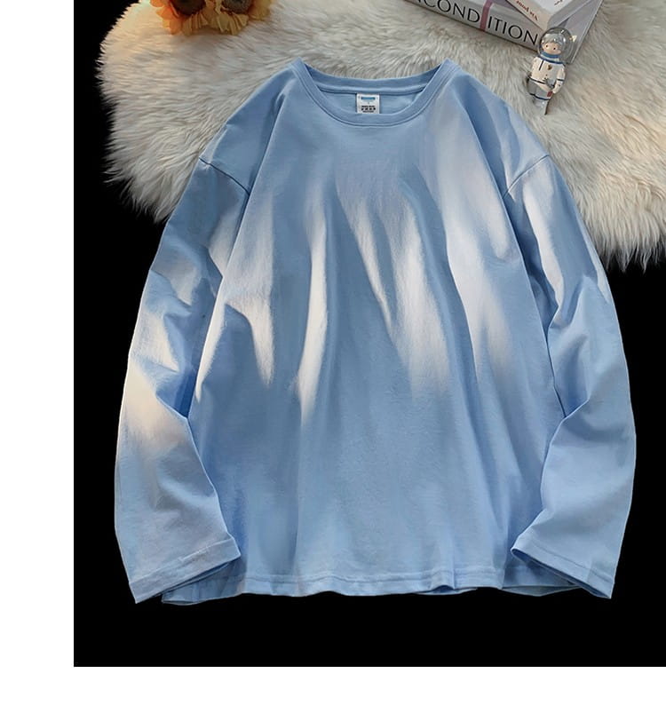 A soft light blue oversized long sleeve blank t-shirt made of cotton with a relaxed fit and simple crew neckline.