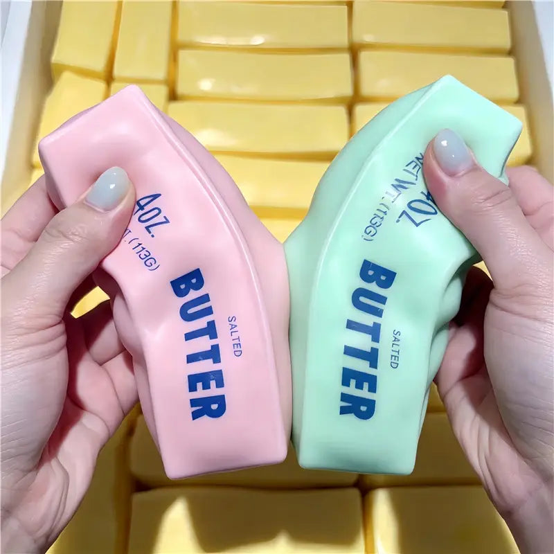 Rosa- und mintgrüner Butterstick als ASMR-Sensory-Squishy-Spielzeug; Verpackungen mit mit blauem Text beschriftet