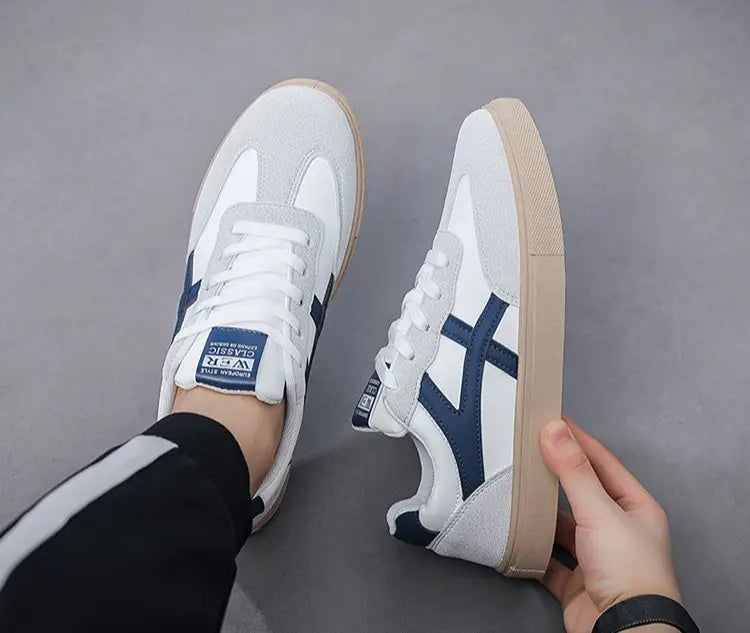 Sneakers décontractées pour hommes, chaussures de marche légères, en daim blanc et bleu marine avec semelle extérieure en caoutchouc beige, portant l’étiquette de la marque Asics sur la languette.