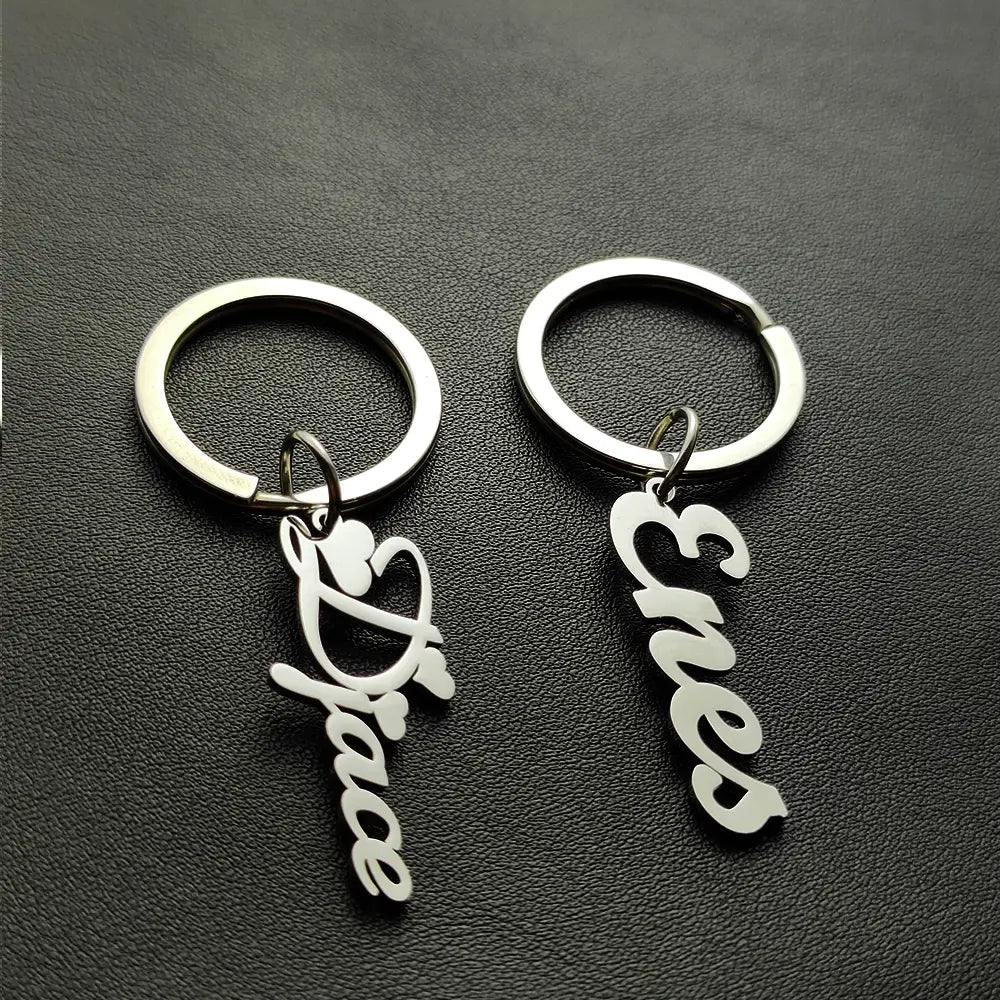 Llavero de nombre personalizado de acero inoxidable, hecho de joyería, con llaveros de metal plateado e incluye amor y paz en diseño de caligrafía cursiva.