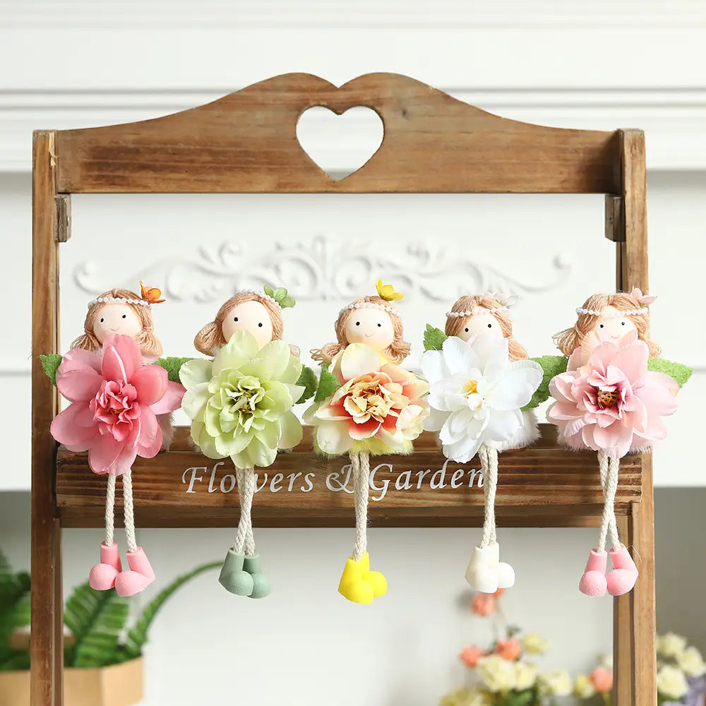 Fünf bezaubernde Oster-Feen- und Osterhasen-Puppen-Anhänger mit floralen Motiven, die Pastellfarbene Stoffblumen sowie baumelnde, farbenfrohe Stiefelchen zeigen.