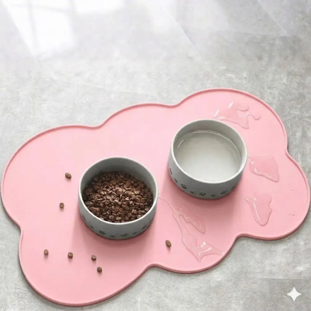 Alfombra de alimentación para mascotas de silicona con forma de nube color rosa con dos cuencos grises con huellas de pata, que contiene alimento seco y agua para perros, gatos pequeños y medianos