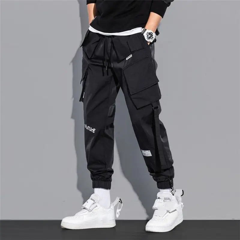 Black teal mens tactical cargo pants with multiple pockets drawstring waistband and white text on the leg designed for streetwear use