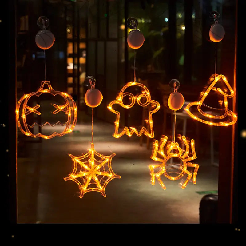 halloween window light battery operated decor featuring orange glowing led lights shaped as a pumpkin ghost witch hat spider web and spider.