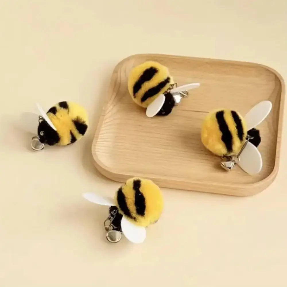 黄と黒の毛むくじゃらのハチのキーホルダーで、白いプラスチック製の翼を備え、ぬいぐるみのようなインタラクティブ猫おびき寄せ玩具のタイプとして設計されたもの。