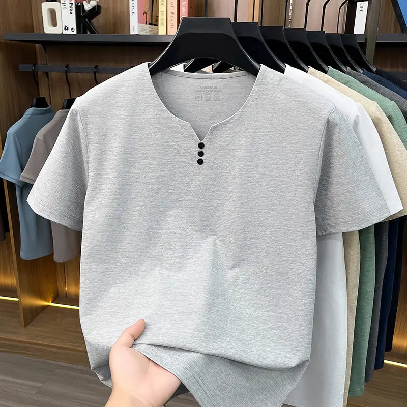 Camisa tipo henley para hombre de manga corta en tejido gris jaspeado, con tres botones negros en el cuello, para un estilo de camiseta informal tipo henley con textura.