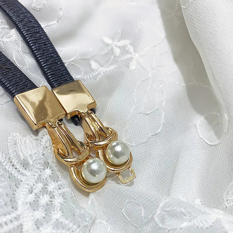 Perlen-Schnallen-Taillegürtel für Damen mit einer goldfarbenen Gürtelschnalle mit zwei Perlenakzenten und einem strukturierten schwarzen Riemen.