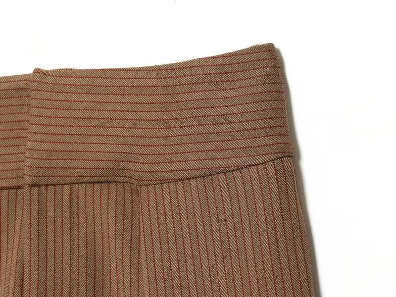Pantalons camel à jambes évasées avec motif chevrons et ceinture côtelée, présentant un design taille haute plissé