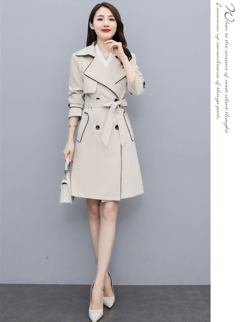 Beige women double breasted trench coat with black trim and belted waist made of lightweight material.