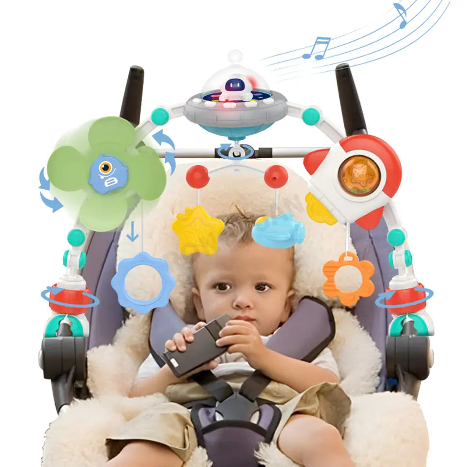 Un bébé est installé dans un transat inclinable pour nourrisson gris et blanc en peluche, avec des jouets d’arche pour poussette de bébé du centre d’activités marin, comprenant des jouets suspendus colorés, dont une fleur verte, une étoile jaune, un engrenage bleu, une fleur orange, une fusée rouge et un vaisseau spatial