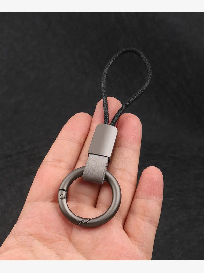 Leather keychain lanyard with a gray metal ring, brown leather strap, and black cord for car key holder use.