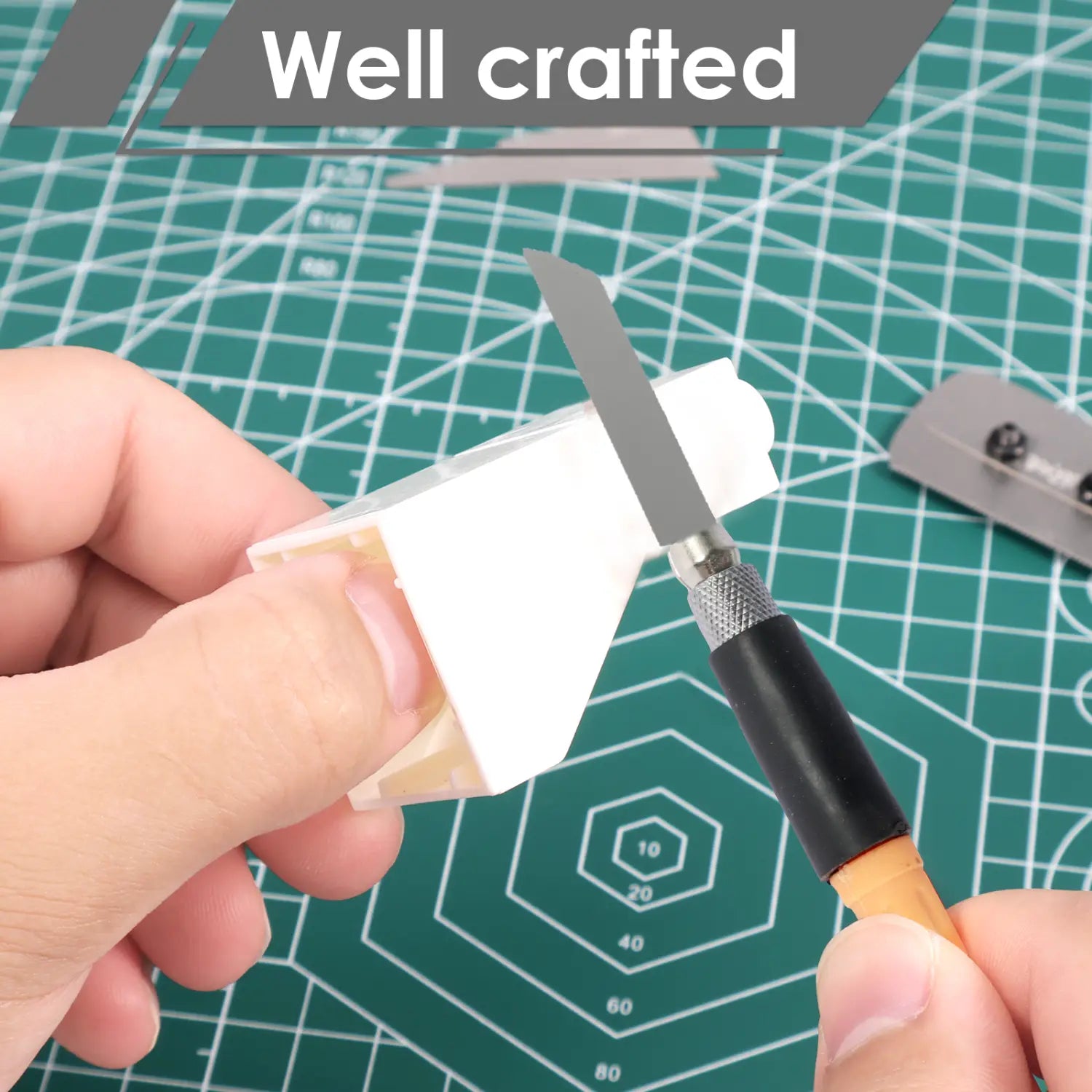 white plastic model airplane body being cut with a craft knife using a mini hand saw kit for precision model making