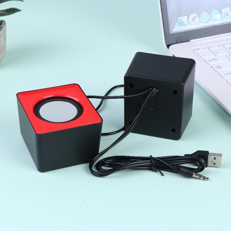 Black and red cube-shaped USB desktop speaker with a circular driver on the front for stereo audio computer system use.