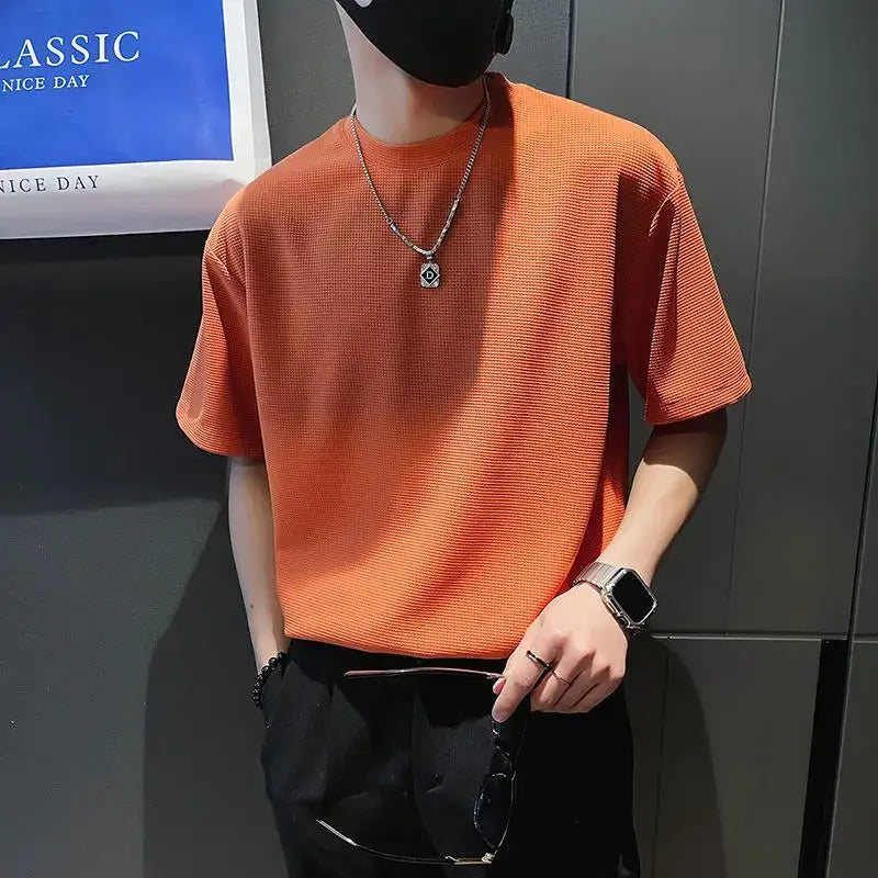 T-shirt à manches courtes et col ras du cou en maille côtelée orange pour homme, avec un motif de tissu texturé.