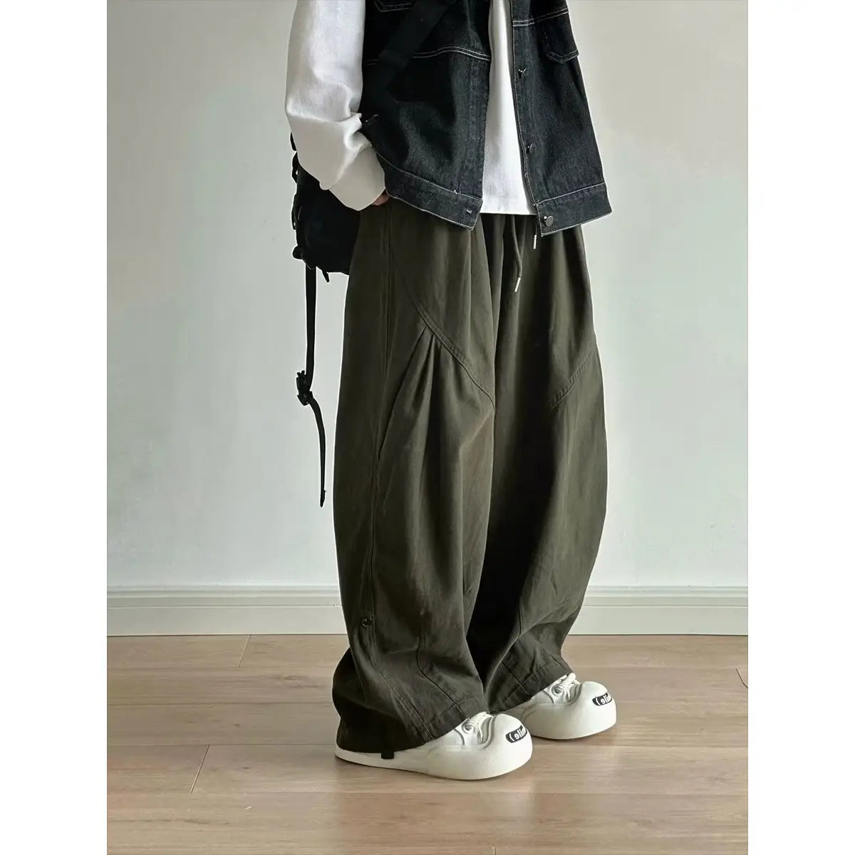 Pantalones cargo de sarga verde oliva para hombre con corte holgado y bolsillos laterales visibles.