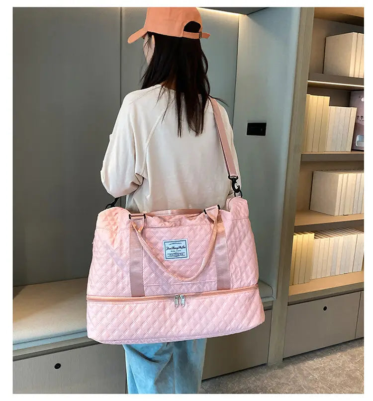 Bolsa de viaje tipo duffel acolchada rosa con correa para el hombro a juego y compartimento frontal con cierre, diseñada como un tote weekender grande para un uso práctico en viajes