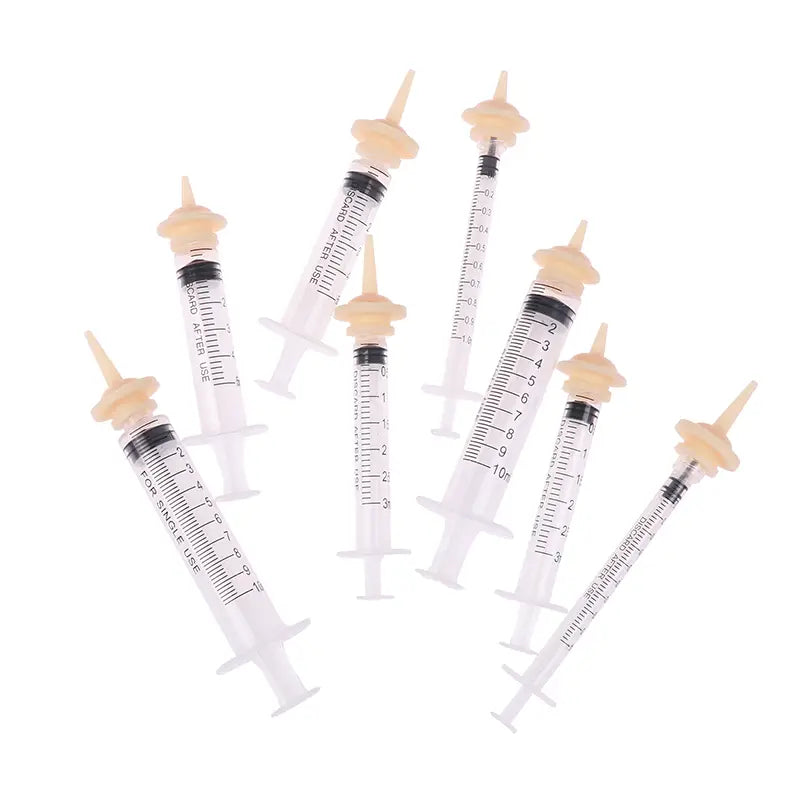 clear plastic pet feeding syringes with beige caps and black measurement markings available in 3ml 5ml 10ml sizes designed for single use with silicone nipple attachments
