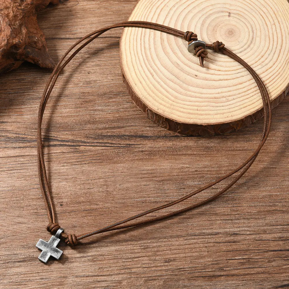 brown leather cord necklace with a silver-toned alloy cross pendant displaying material alloy craftsmanship.