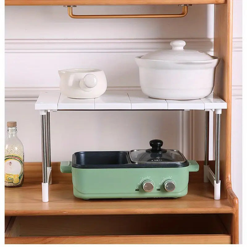 Étagère-organisateur de rangement avec surface carrelée blanche, avec des pieds en acier inoxydable et des embouts en plastique blanc, conçue comme support de rangement pour cuisine.