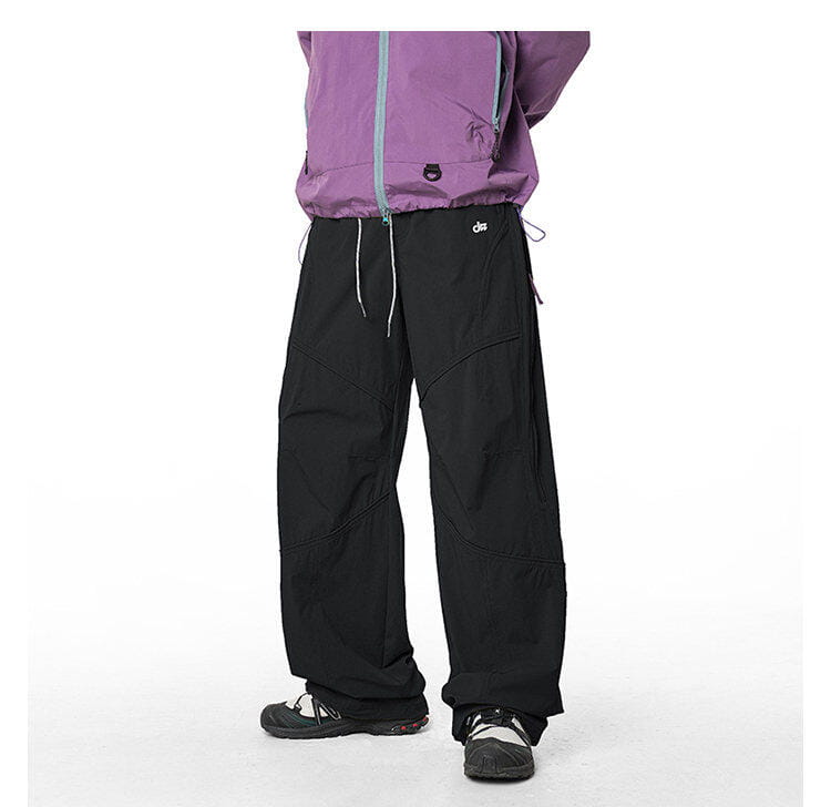 pantalones cargo impermeables de senderismo para hombre en negro, con ajuste relajado, múltiples bolsillos, cordones grises sutiles y tejido de secado rápido.