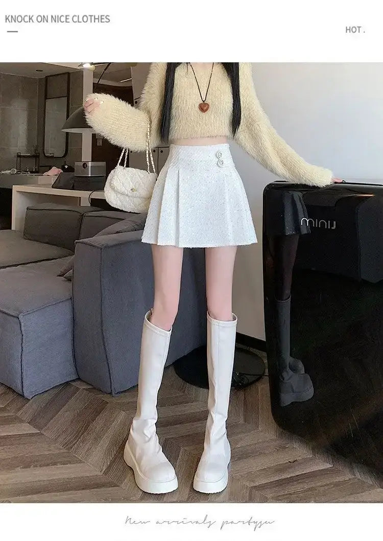 Weißer Falten-Minirock mit dezent glitzernder Textur und kleinem silberfarbenem Knopfdetail am Bund, dargestellt im Rahmen der Kollektion „rosa Bouclé-Falten-Minirock“.