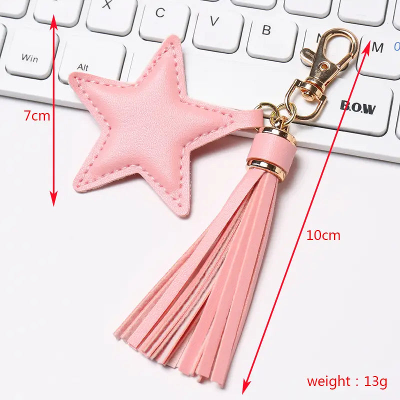 Pink star-shaped leather keychain for women with a matching tassel and gold-tone metal clasp.