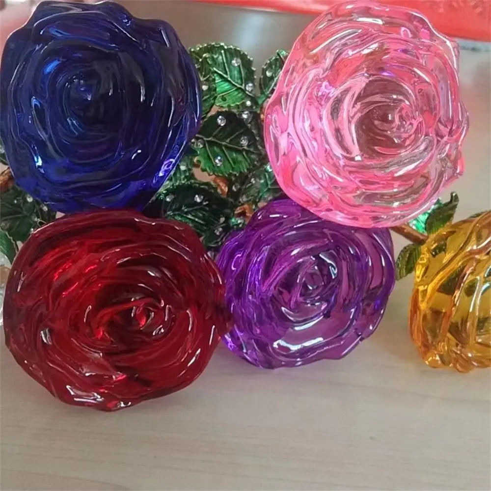 Vibrant translucent crystal glass roses in deep blue pink red purple and yellow hues with jeweled green leaves for a Valentine’s Day gift.
