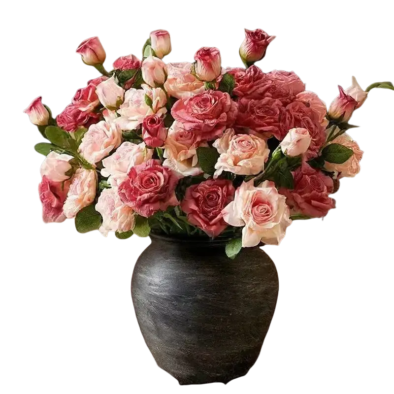 A burnt edge rose bouquet with pink and cream roses in a matte black ceramic vase shown from the front