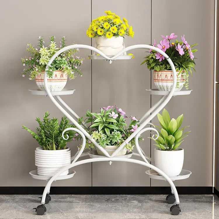Blumenständer aus weißem Metall in Herzform mit vier Ebenen und schwarzen Rollrädern zur Präsentation von Blumentöpfen