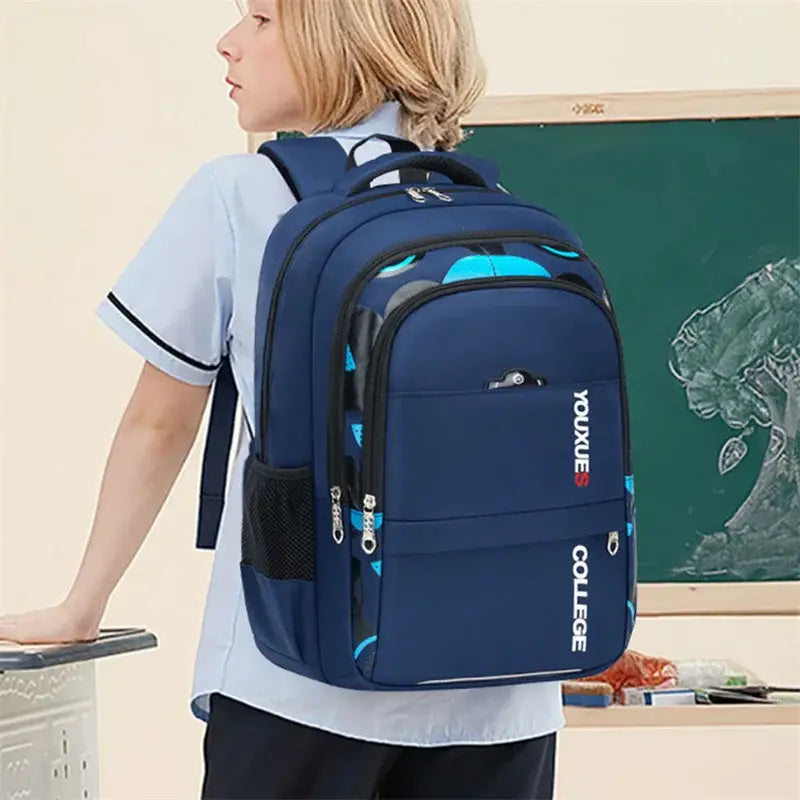 Navyblauer Jungen-Wasserschulrucksack mit hellblauen und schwarzen geometrischen Mustern sowie College-Branding „youxue college“ in weißer, vertikal angeordneter Schrift auf der Vorderseite.