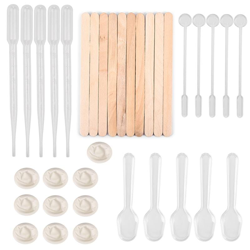 Clear plastic droppers wooden popsicle sticks and clear plastic spoons neatly arranged on a white background in an epoxy resin mixing tool set for diy jewelry making.