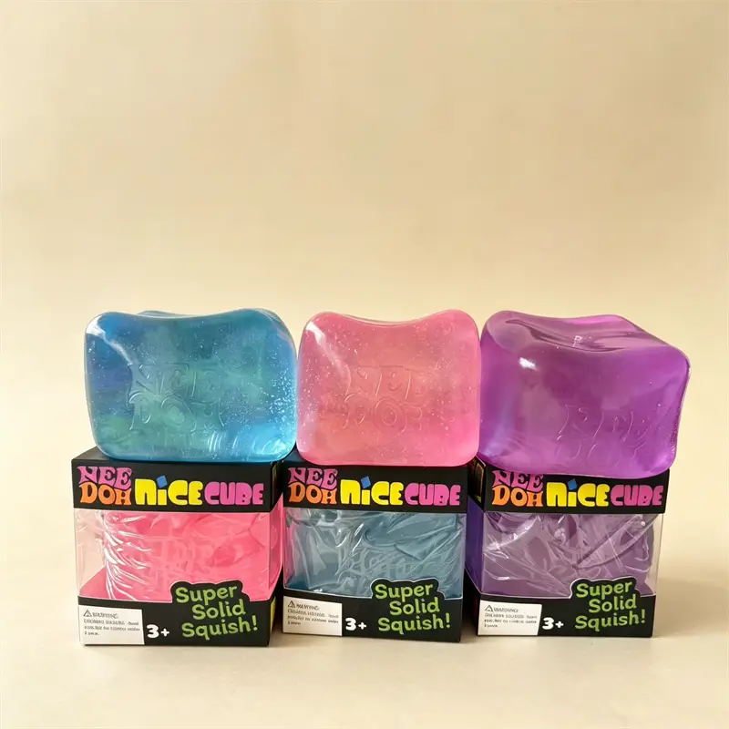 Three colorful translucent Needoh Nice Cube fidget toys in blue pink and purple are displayed on branded packaging.