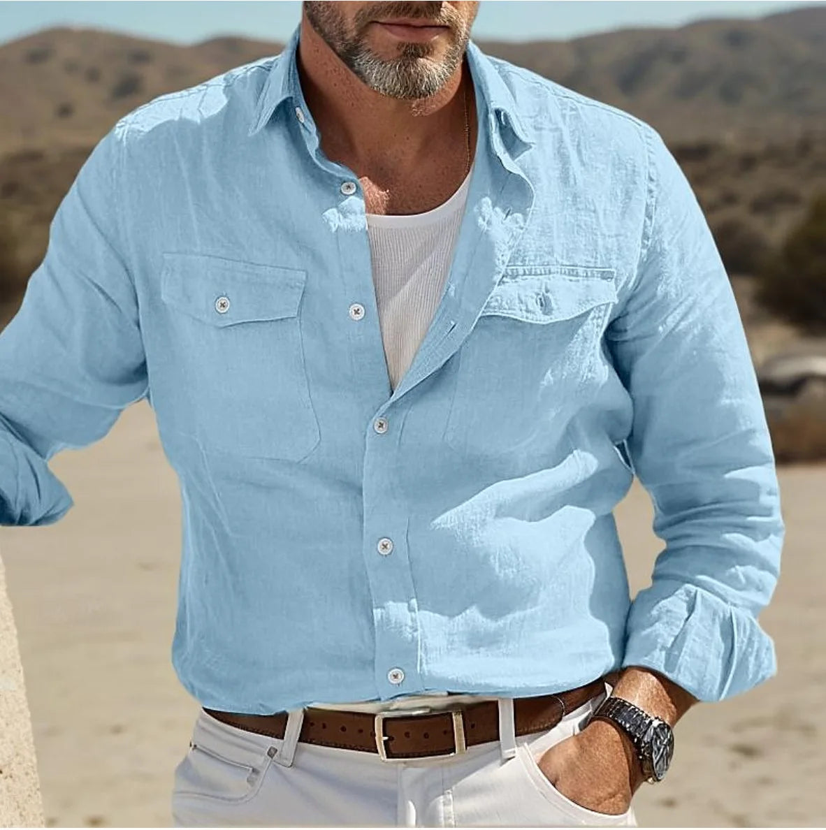 Men casual linen button up shirt in light blue with long sleeves two chest pockets and white buttons.