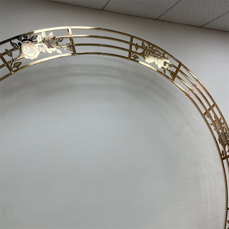 support de fond d’arche de mariage dorée en métal avec un motif découpé complexe de rose et de feuilles dans une finition dorée pour des réceptions et des événements.