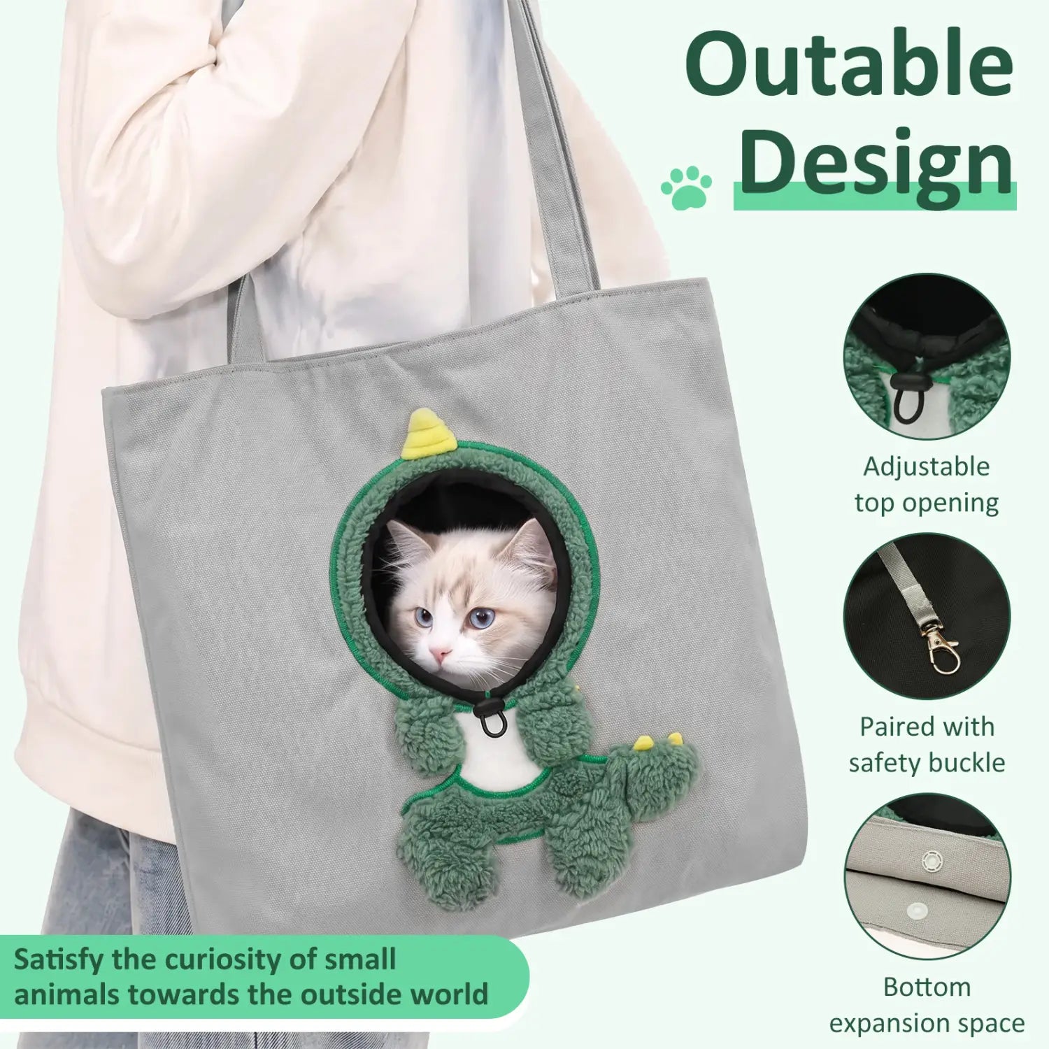 Sac de transport en tissu gris pour petits chiens, avec une entrée en forme de dinosaure vert en peluche et une boucle de sécurité pour un transport sécurisé.