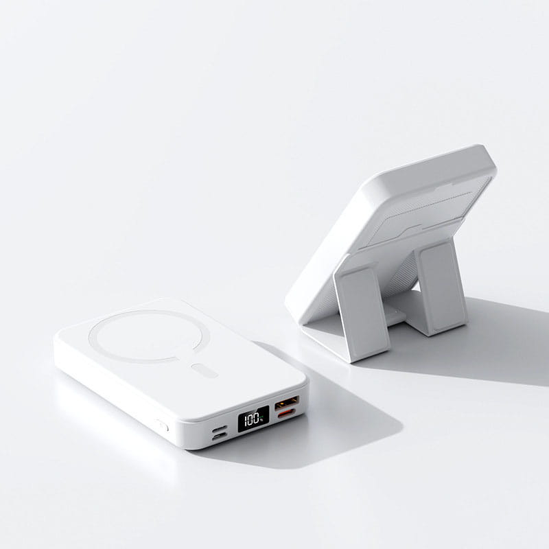 White rectangular magnetic power bank with digital display showing 100 percent charge and multiple USB ports on a matching stand designed for fast charging support and phone use.