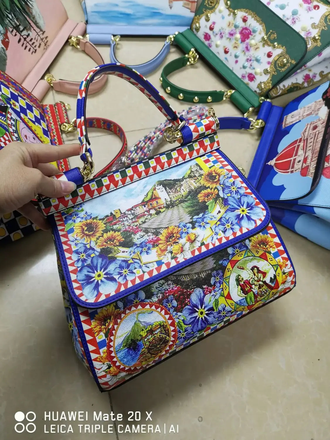 Sac bandoulière en cuir vintage, art raffiné, présentant un design vibrant imprimé floral, avec des accents bleu, jaune et rouge audacieux.