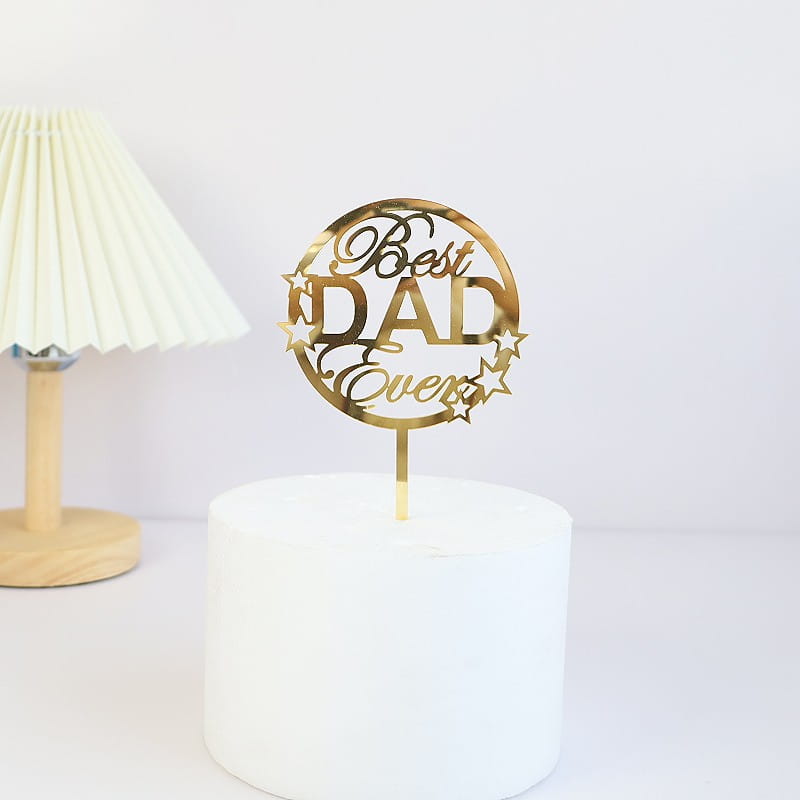 Gold metallic acrylic cake topper with best dad ever script and star accents for Father’s Day celebration.