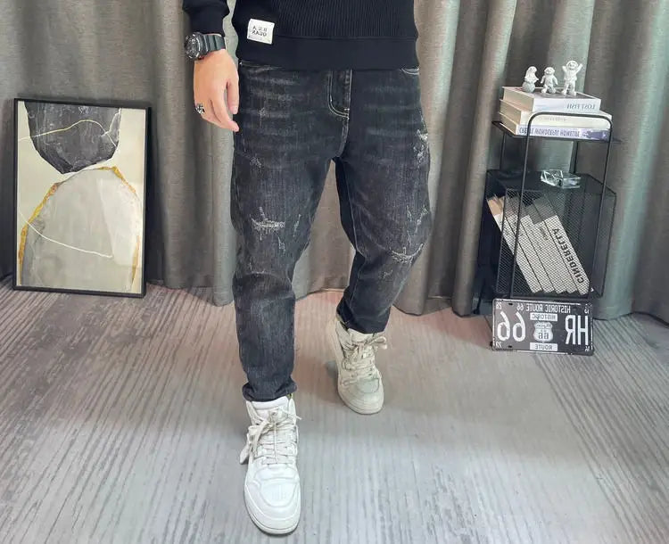 Jean en denim à lavage foncé avec détails déchirés et effilochés, coupe ajustée, associé à un pull-over en maille à empiècement contrastant pour homme, manches longues.