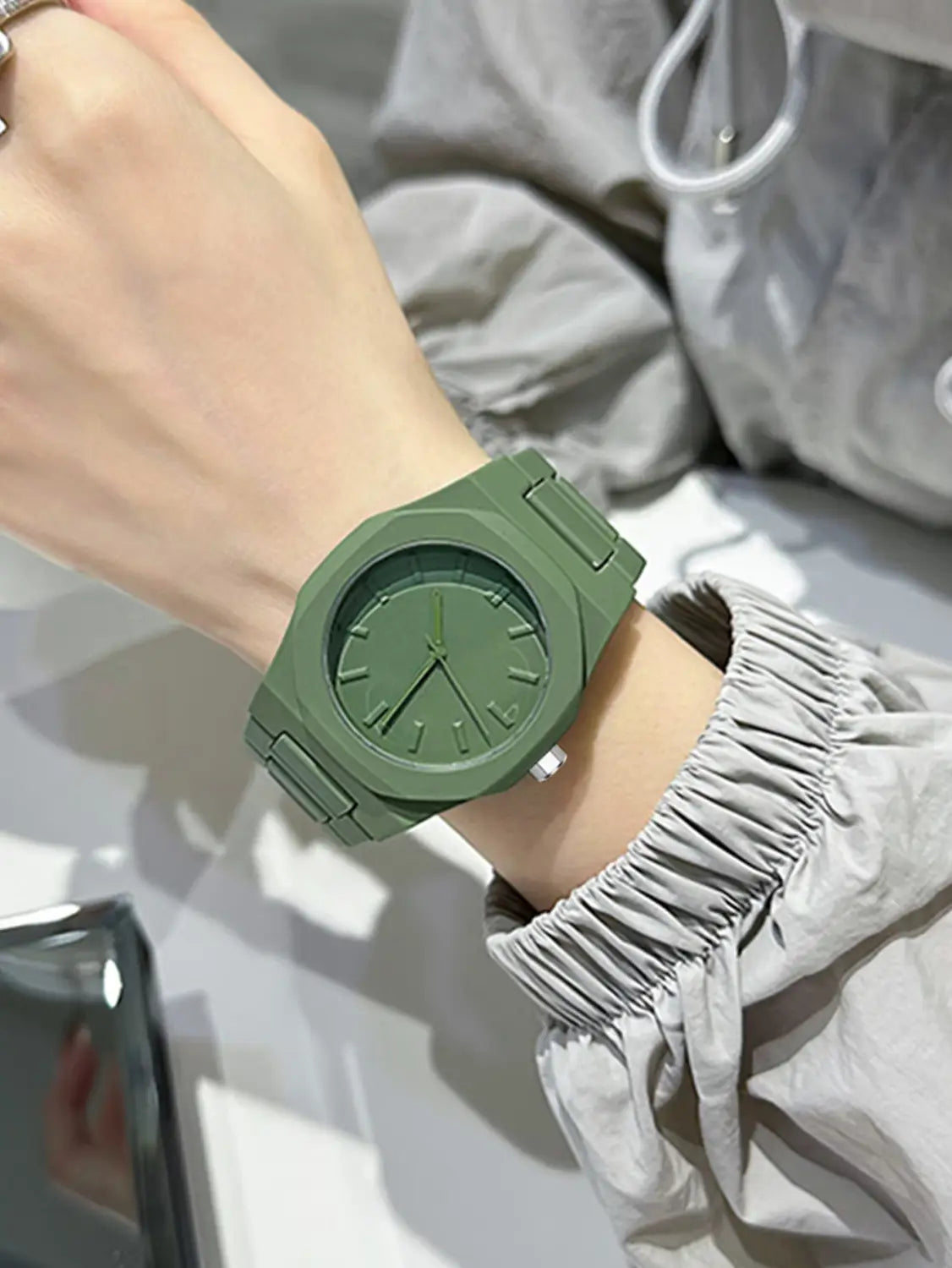 Herrenarmbanduhr Tomi im minimalistischen Design aus weißer Keramik mit einem olivgrünen Silikonarmband, einem minimalistischen Zifferblatt und einem kantigen Gehäusedesign.
