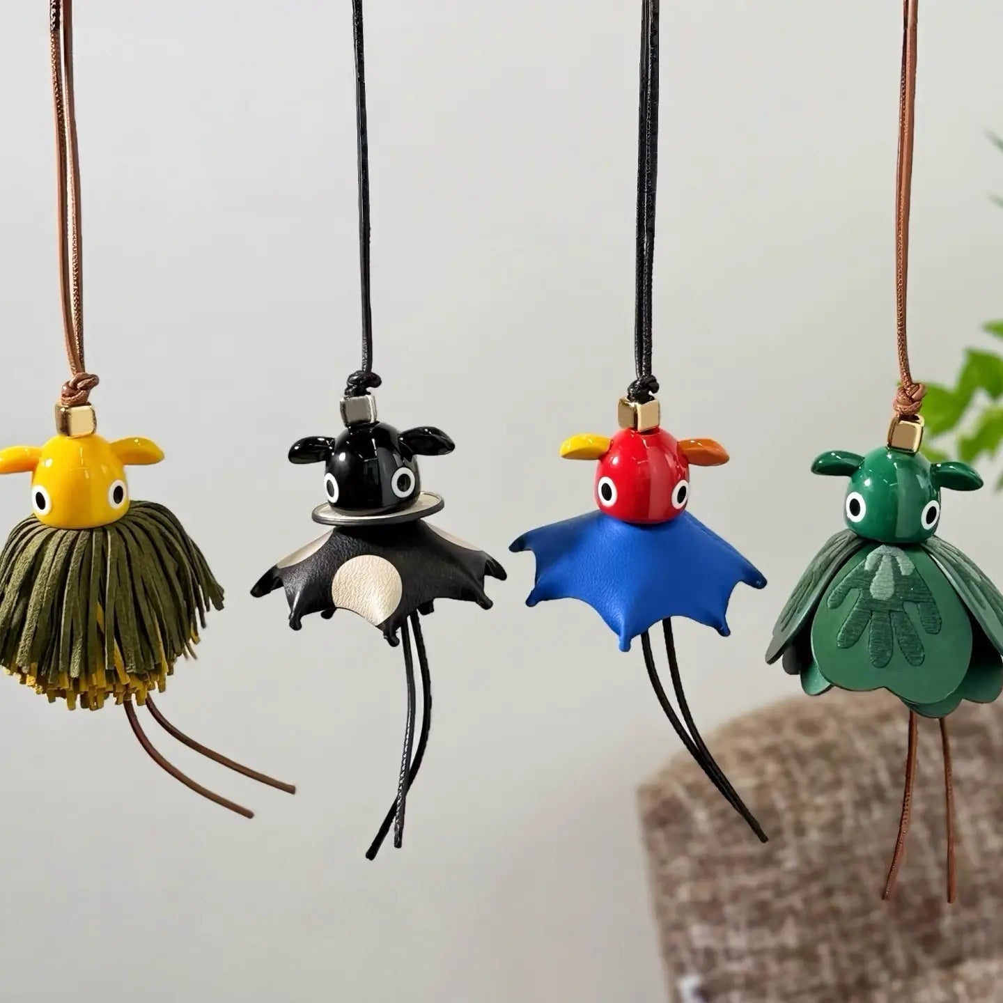 Cuatro llaveros colgantes para bolso con encanto de animales de cuero artesanal y colorido cuentan con criaturas caprichosas, ojos expresivos y diseños únicos.