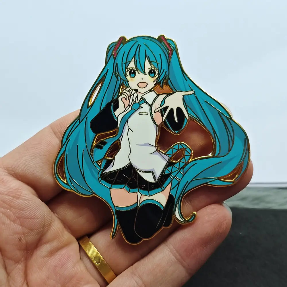 A vibrant blue-haired Hatsune Miku anime enamel pin with gold-trimmed edges featuring a white blouse and black skirt metal badge.
