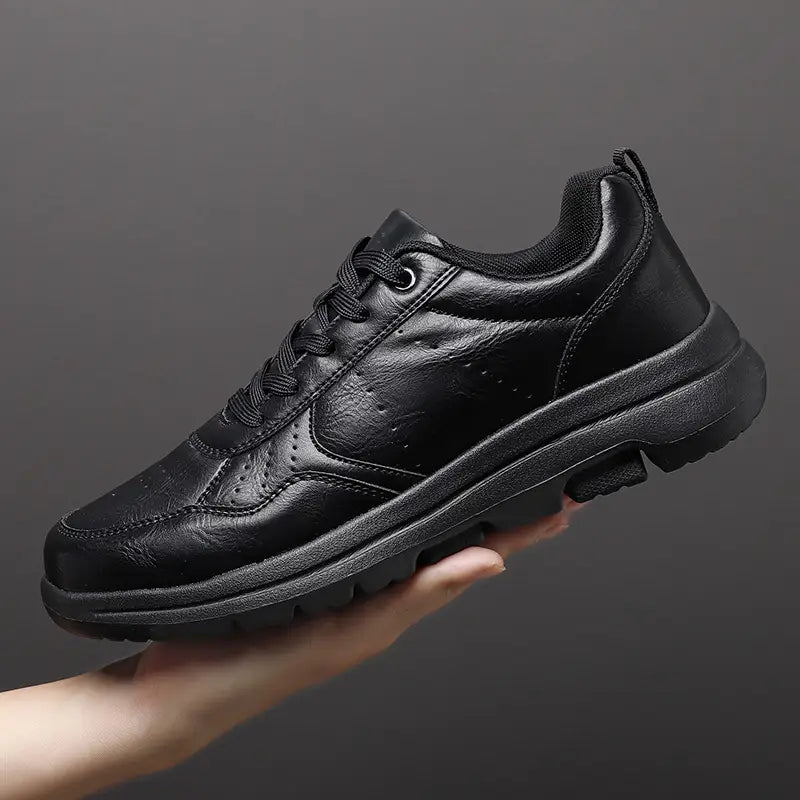 Men black leather chunky sole sneakers featuring a perforated design and a chunky rubber sole.