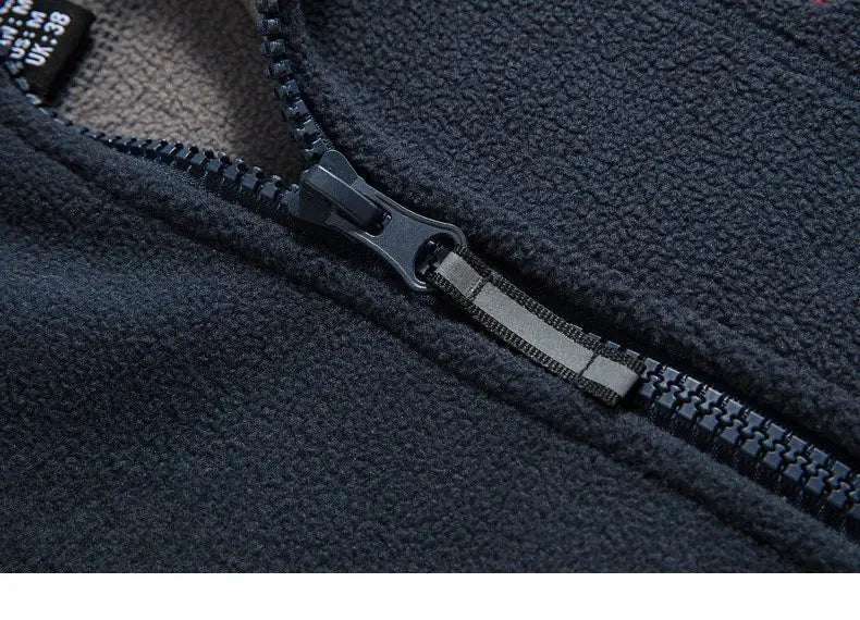 Chaqueta de invierno de forro polar para hombre en gris oscuro, con cremallera y lengüeta de plástico negra, además de tira reflectante para ropa de abrigo y exterior cálida.