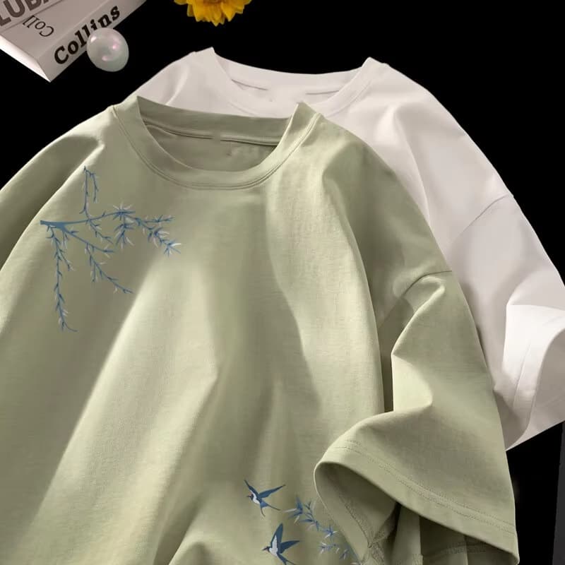 Camiseta de algodón oversize suave color verde menta con delicadas ramas bordadas en azul y pájaros.