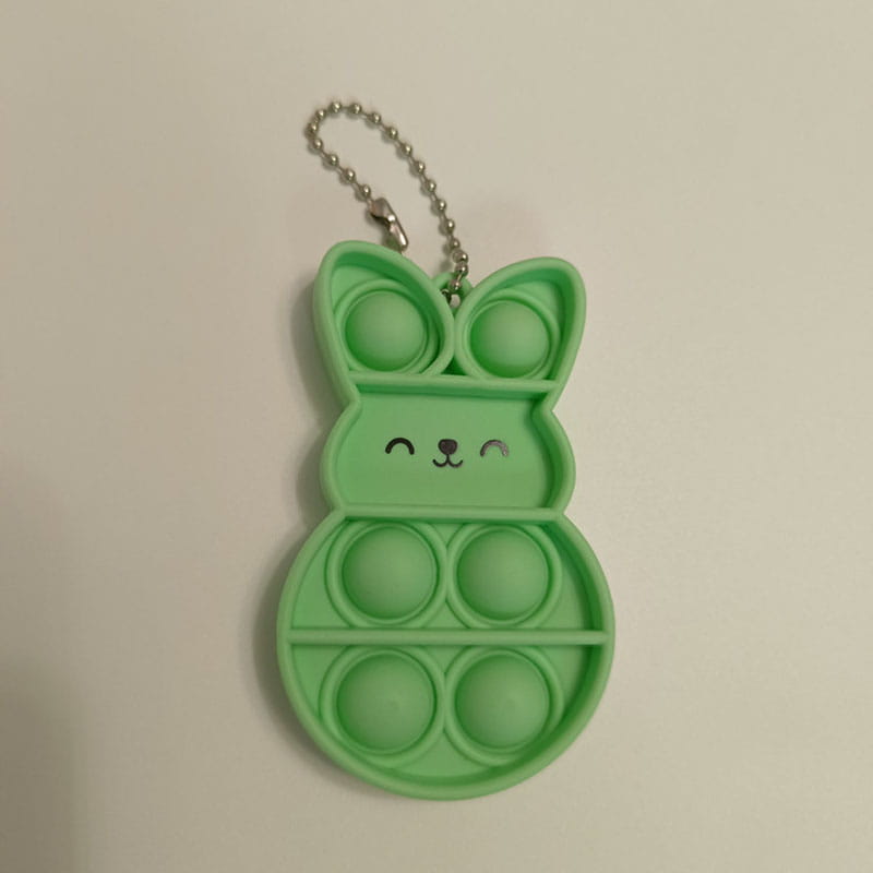A lime green bunny-shaped pop it fidget keychain with a silver chain designed for stress relief and key organization.